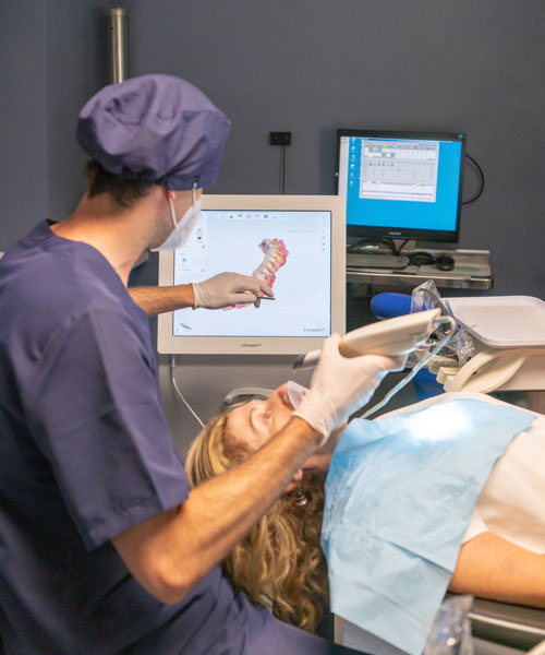 Dentista realizando escáner intraoral a una paciente