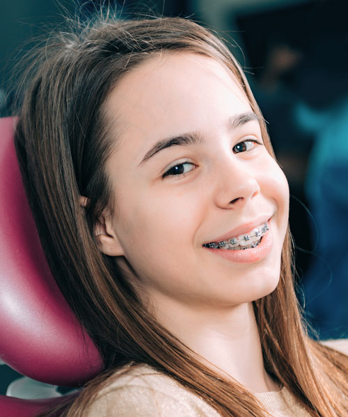 Niña sonriendo con brackets metálicos